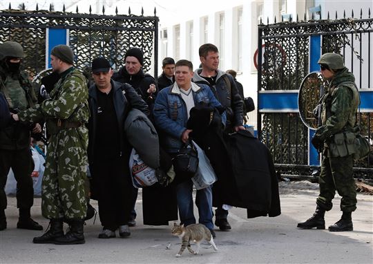 Sewastopol, 19. März: Ukrainische Soldaten in Zivil verlassen, von russischen Soldaten eskortiert, ihre Kaserne.