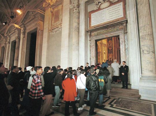 Pilger gehen durch die Heilige Pforte in Rom